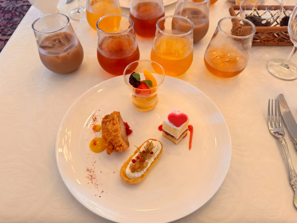 2025年東京ディズニーシー紅茶プログラムで、紅茶と一緒に提供されたフードペアリングプレートがテーブルに運ばれてきた様子